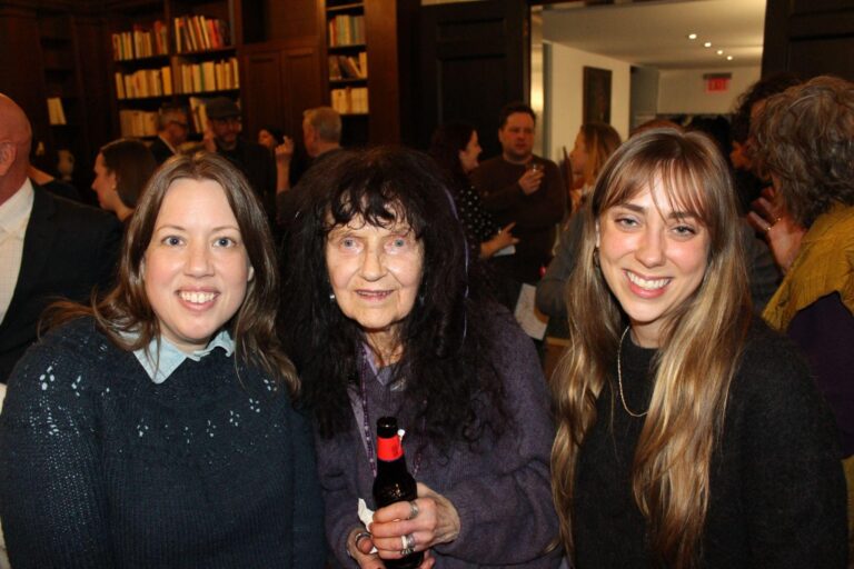 a photo of three women facing forward with a crowd of people in the background